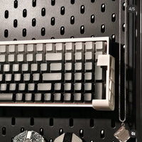 Mechanical keyboard on a pegboard with various items