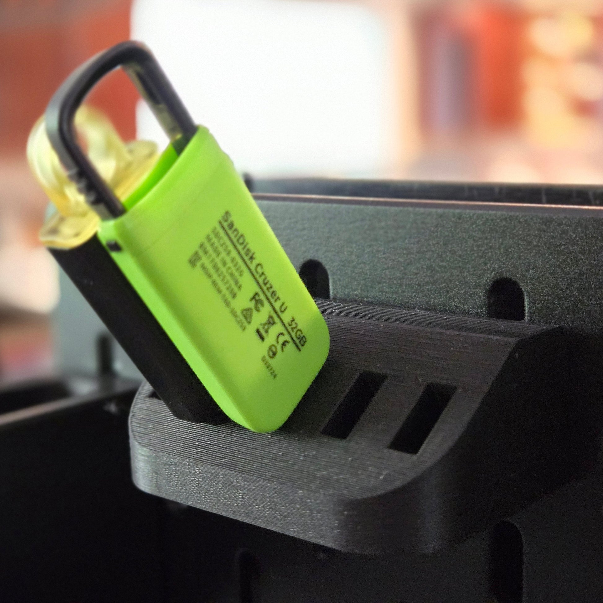 Green lock attached to a black metal surface with a blurred background